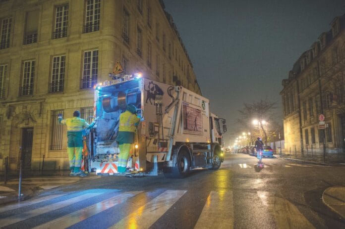 French Refuse Truck with Workers on Back