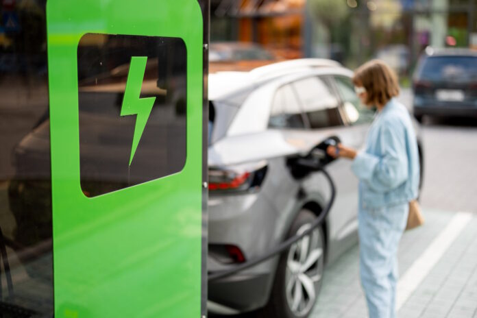 Woman charging her car on public fast charger